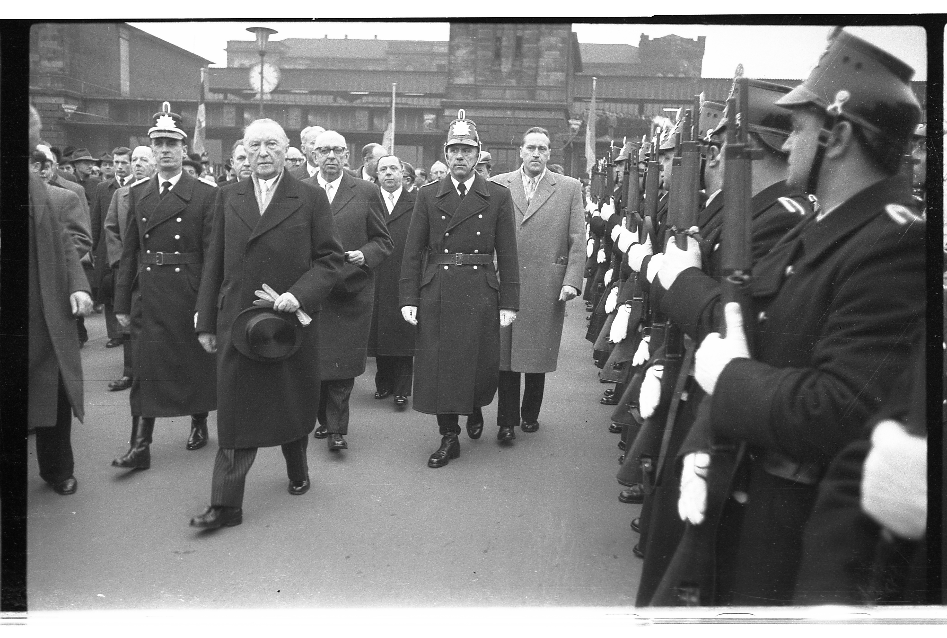 Bundeskanzler Adenauer schreitet nach seiner Ankunft in Saarbrücken die vor dem Hauptbahnhof aufgestellte Ehrenformation der saarländischen Bereitschaftspolizei ab.